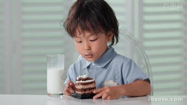可爱的小男孩喝牛奶吃蛋糕